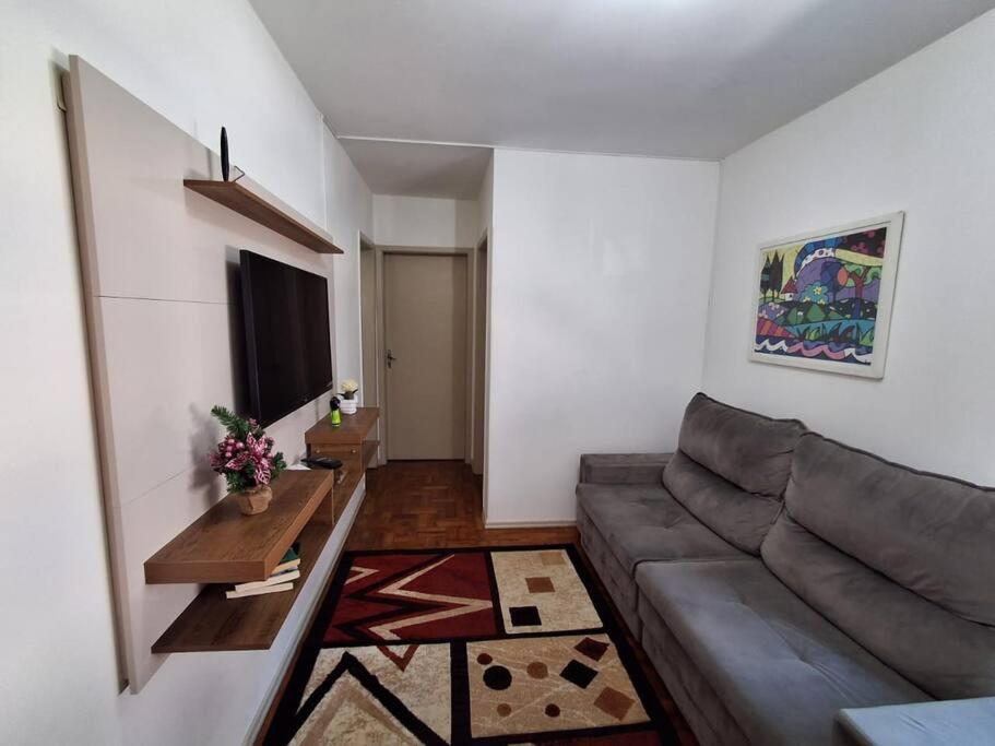 a living room with a couch and a table at Charmoso apartamento próximo ao Consulado EUA in Porto Alegre