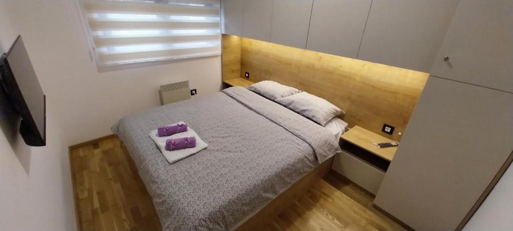 1 dormitorio pequeño con 1 cama con 2 almohadas moradas en Zeleni Raj, en Zlatibor