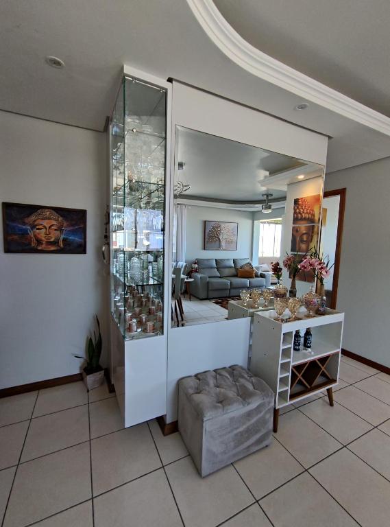 a living room with a large glass display case at Apto 2 dorm com vista para o mar in Capão da Canoa