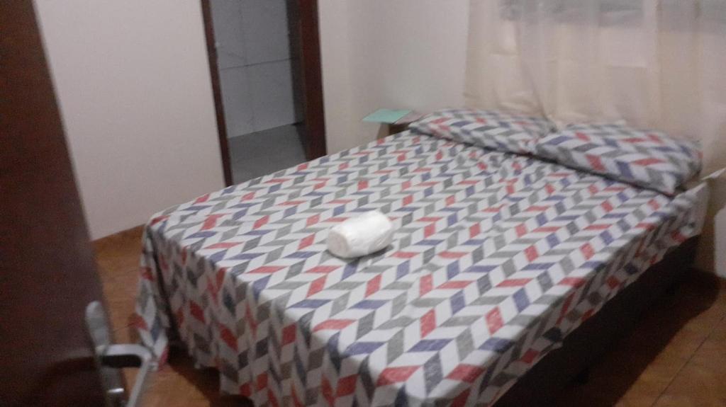 uma cama com um rato de computador em cima em Hostel Casa Uniao em Maracaju