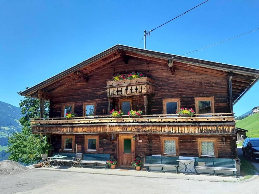 a wooden building with benches in front of it at Spacious holiday home in Distelberg with sauna in Aschau