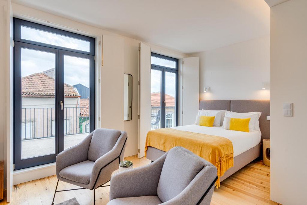 Una habitación de hotel con una cama y dos sillas. en Alma da Casa by DA'HOME, en Oporto