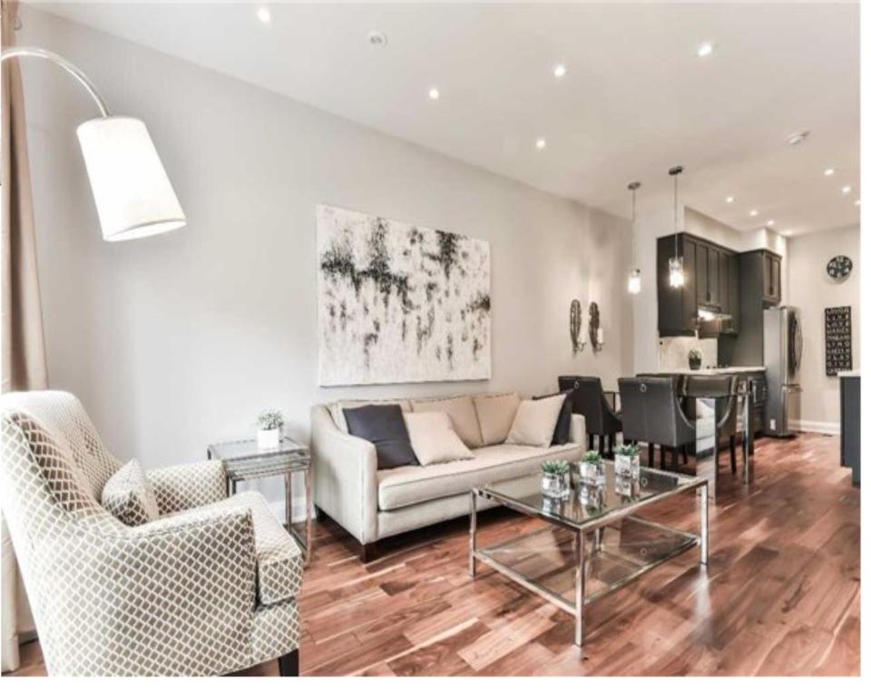 un soggiorno con divano e tavolo di Immaculate Executive Townhouse 3Br&3Ba at Lawrence Park a Toronto