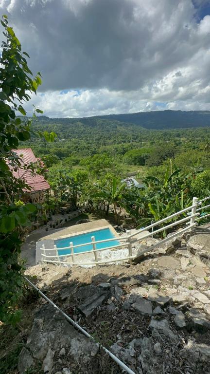 a swimming pool on a hill with a fence at Ecovillalova in Camú