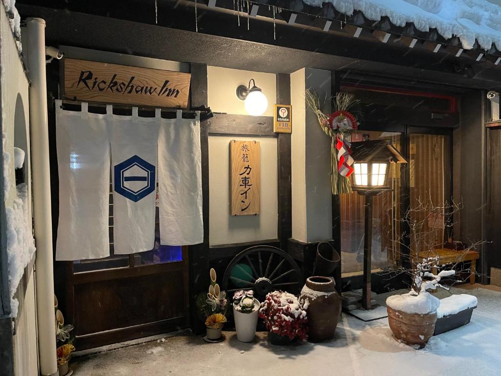 um quarto com uma bandeira e uma roda na parede em Rickshaw inn em Takayama