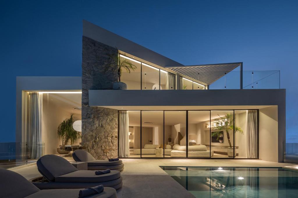 a large house with a swimming pool in front of it at Luxury 4BR Ocean View Villa Near Bingin Beach in Uluwatu