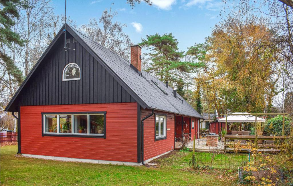une maison rouge et noire avec un toit noir dans l'établissement Lovely Home In Hllviken With Kitchen, à Höllviken