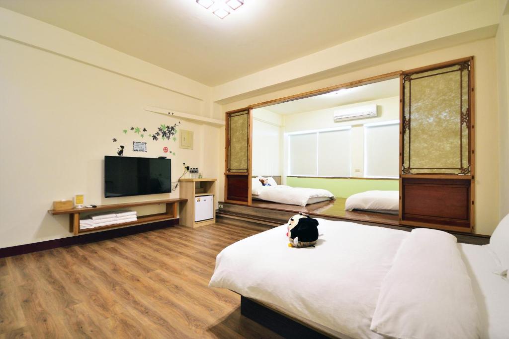 a room with two beds and a flat screen tv at Jamie home stay in Taitung City