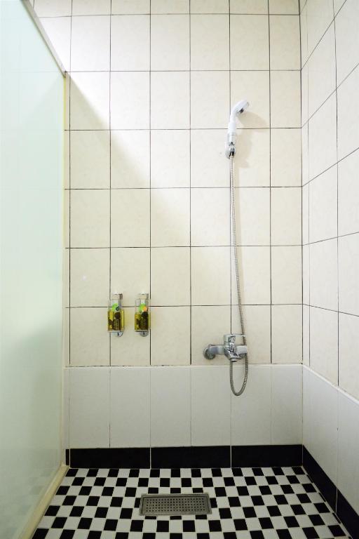 a shower stall with a black and white checkered floor at Jamie home stay in Taitung City