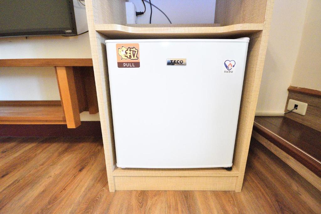 a white refrigerator in a room next to a tv at Jamie home stay in Taitung City