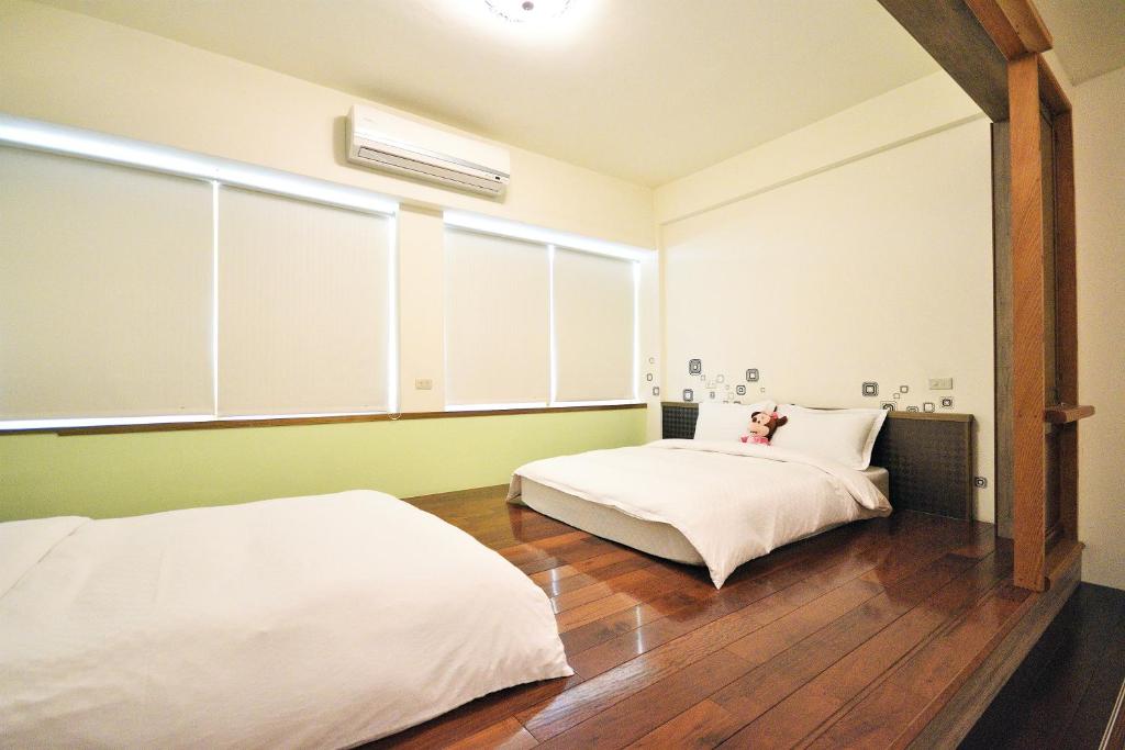 a bedroom with two beds and a window at Jamie home stay in Taitung City