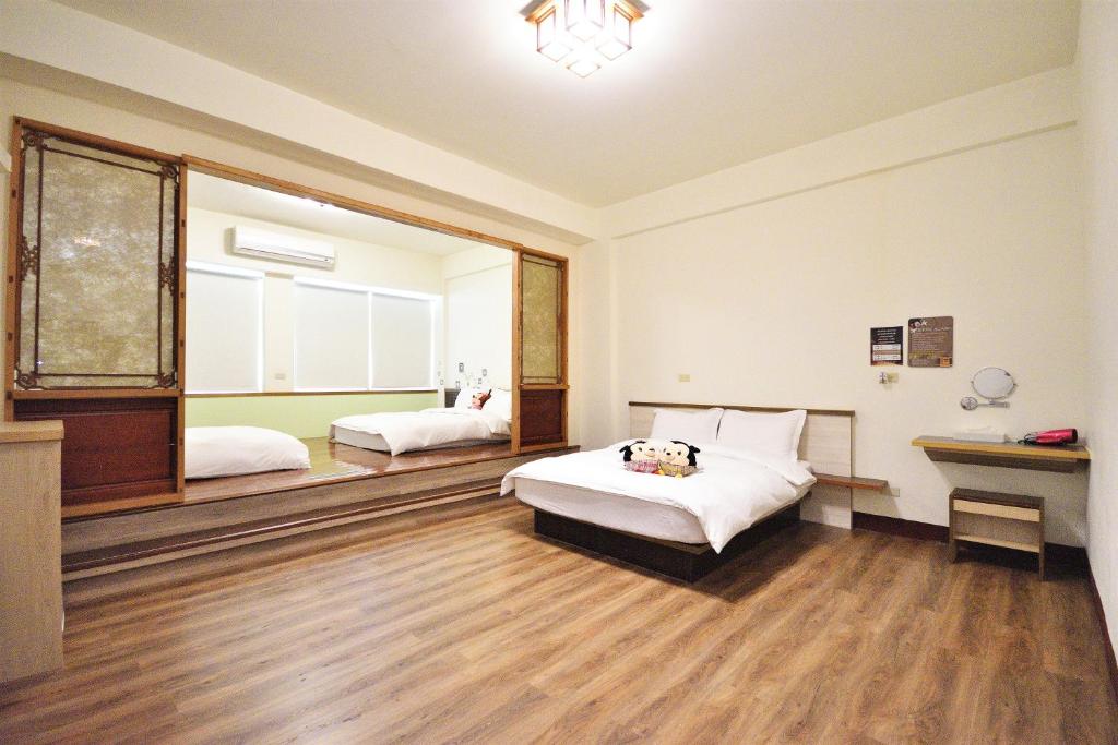 a bedroom with two beds and a desk in it at Jamie home stay in Taitung City