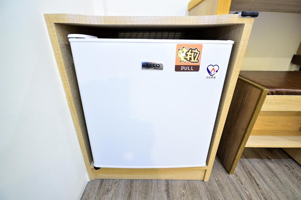 a white refrigerator in a kitchen next to a table at Jamie home stay in Taitung City