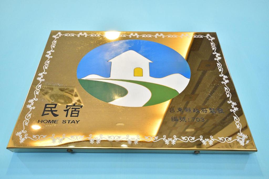 a gold plaque with a picture of a home stay at Jamie home stay in Taitung City
