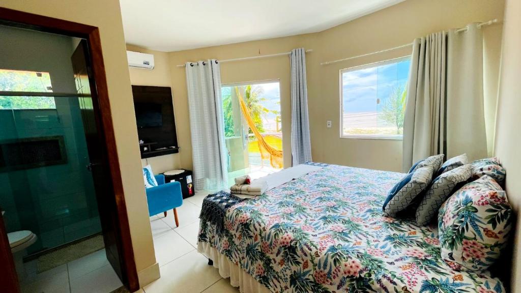 a bedroom with a bed and a large window at Pousada OPA - O Paraíso é Aqui Abrolhos in Caravellas