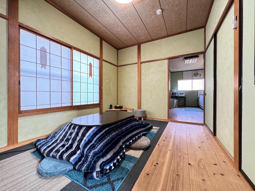 Calmbase Nishi Izu - Vacation STAY 30929v في Toda: غرفة مع طاولة وبطانية على الأرض