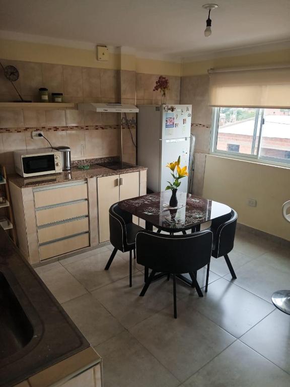 a kitchen with a table with a vase of flowers on it at Departamento Letty II - Con cochera in San Salvador de Jujuy