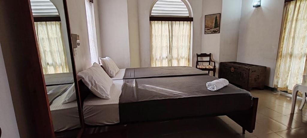 1 dormitorio con 1 cama y 2 ventanas en Jays Guest, Diyatha Uyana, en Etulkotte