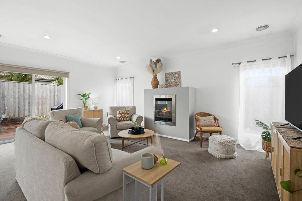a living room with a couch and a fireplace at Salty Sage Beach House in Torquay