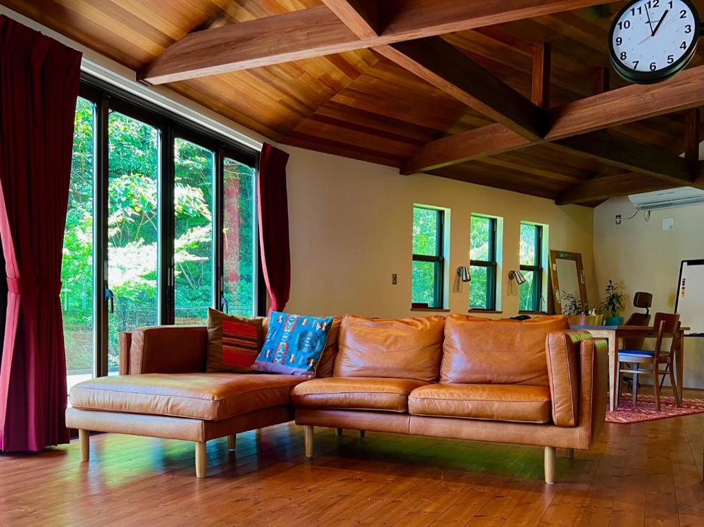 a living room with a couch and a clock on the wall at 極楽寺邸 - Gokurakuji House in Kamakura