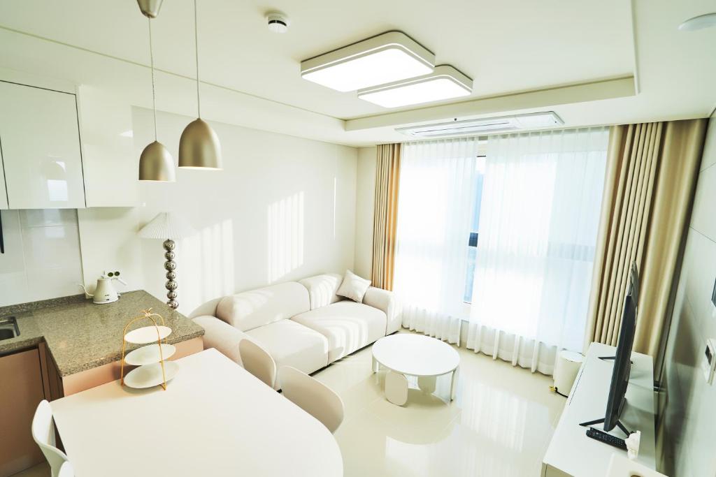 a living room with a white couch and a table at The November Stay In landmark in Incheon