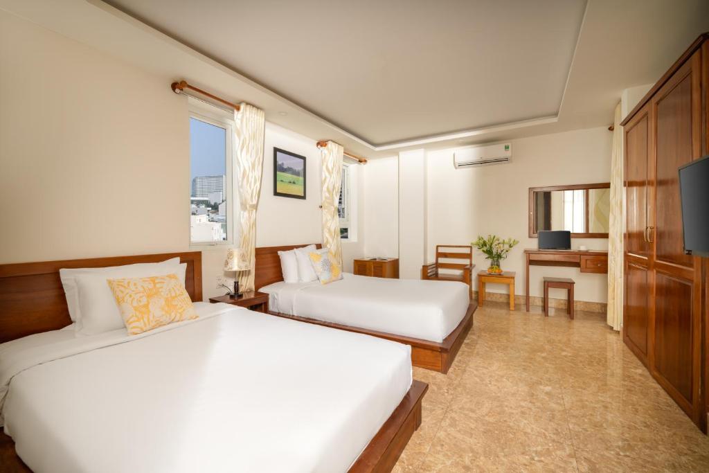 Postel nebo postele na pokoji v ubytování Titan Hotel Da Nang