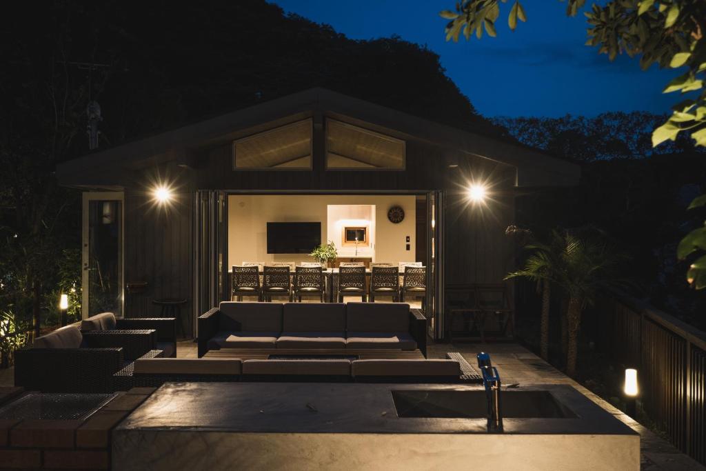 ein Haus mit einem Sofa und einer Terrasse in der Nacht in der Unterkunft Monterey House by SANA in Tateyama