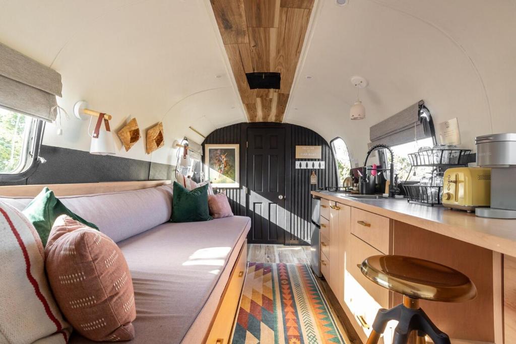 a living room with a couch and a kitchen at Silver Bullet Airstream, El Mistico Glamping Ranch in Nogal
