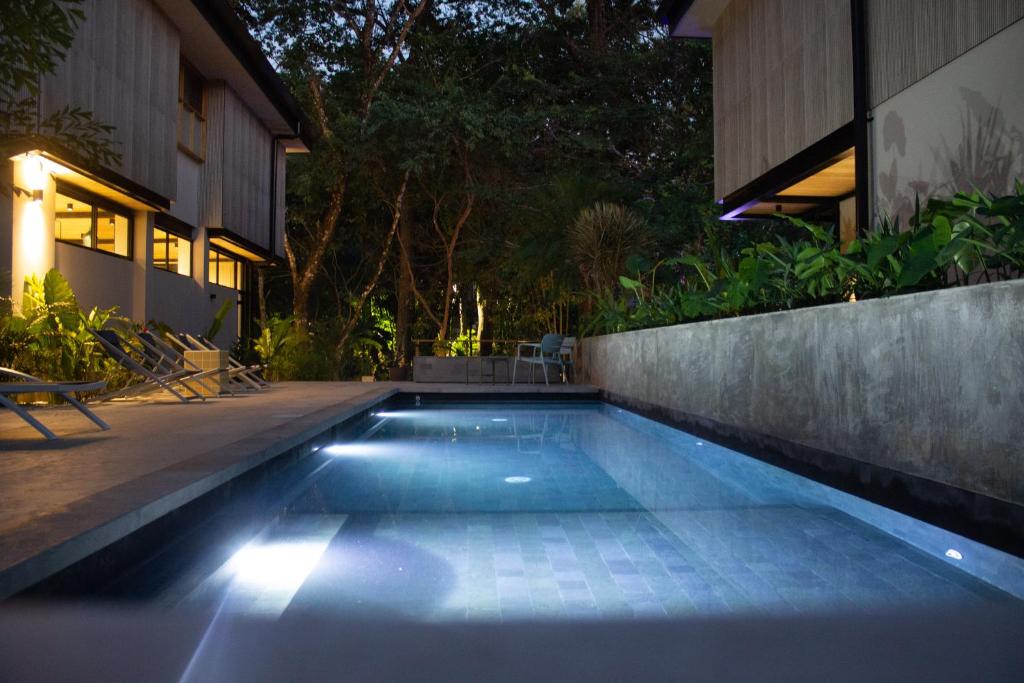 a swimming pool in a backyard at night at D'Palm Villas in Puntarenas