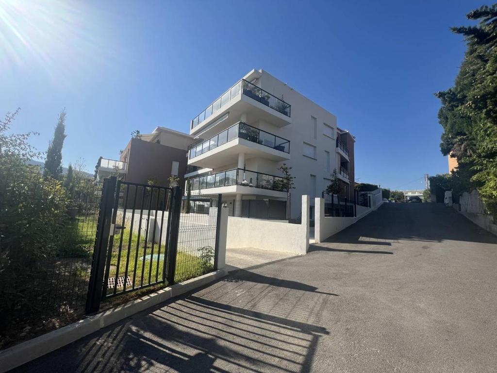 un bâtiment blanc avec une porte devant dans l'établissement Appartement T3 climatisé avec terrasse à La Ciotat – Idéal pour 4-5 personnes, proche du Vieux Port - FR-1-770-4, à La Ciotat