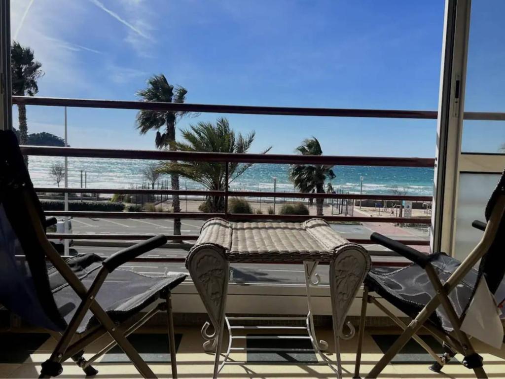 uma mesa e cadeiras numa varanda com vista para a praia em Appartement Saint-Cyr-sur-Mer, 2 pièces, 4 personnes - FR-1-770-15 em Saint-Cyr-sur-Mer