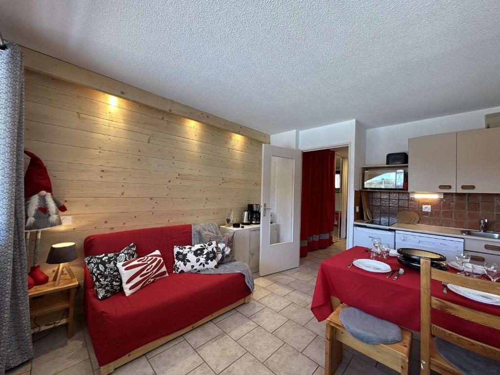 un salon avec un canapé rouge et une cuisine dans l'établissement Montgenèvre : Studio rénové, ski aux pieds, 4 pers., parking inclus, animaux acceptés - FR-1-330D-135, à Montgenèvre