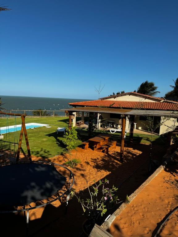 Blick auf ein Haus mit einem Tisch und Stühlen in der Unterkunft Casa de praia Aurora in Icapuí