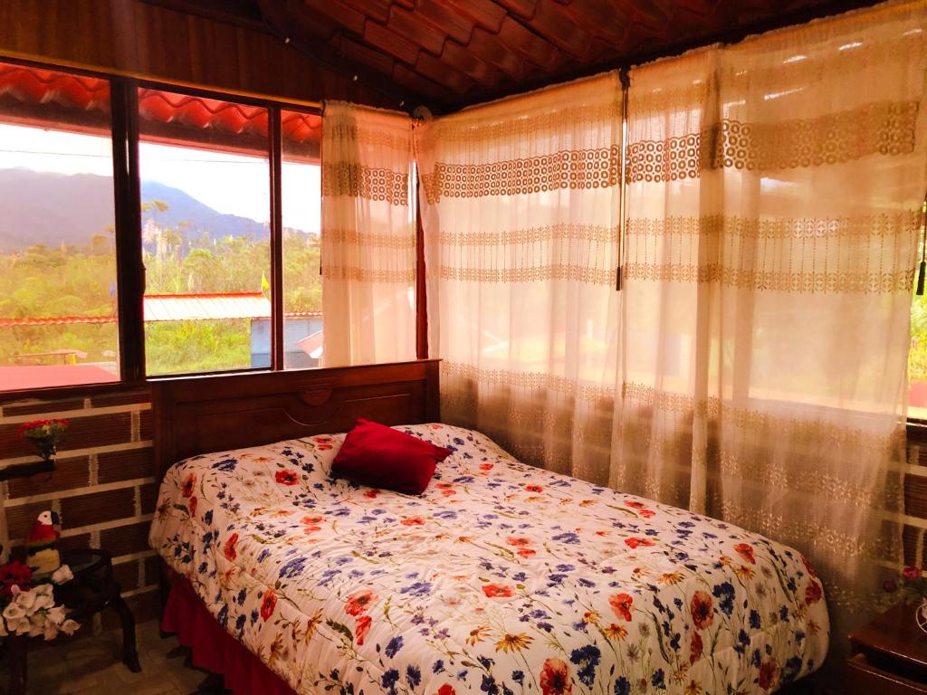 a bedroom with a bed with a red pillow on it at Hospedaje Valentina in Mera