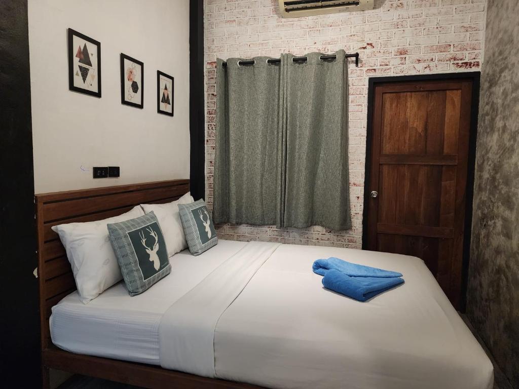 sypialnia z dużym białym łóżkiem z niebieskimi poduszkami w obiekcie Baan Minnie 2 bedroom home 400m from Saikaew beach w mieście Ko Samet