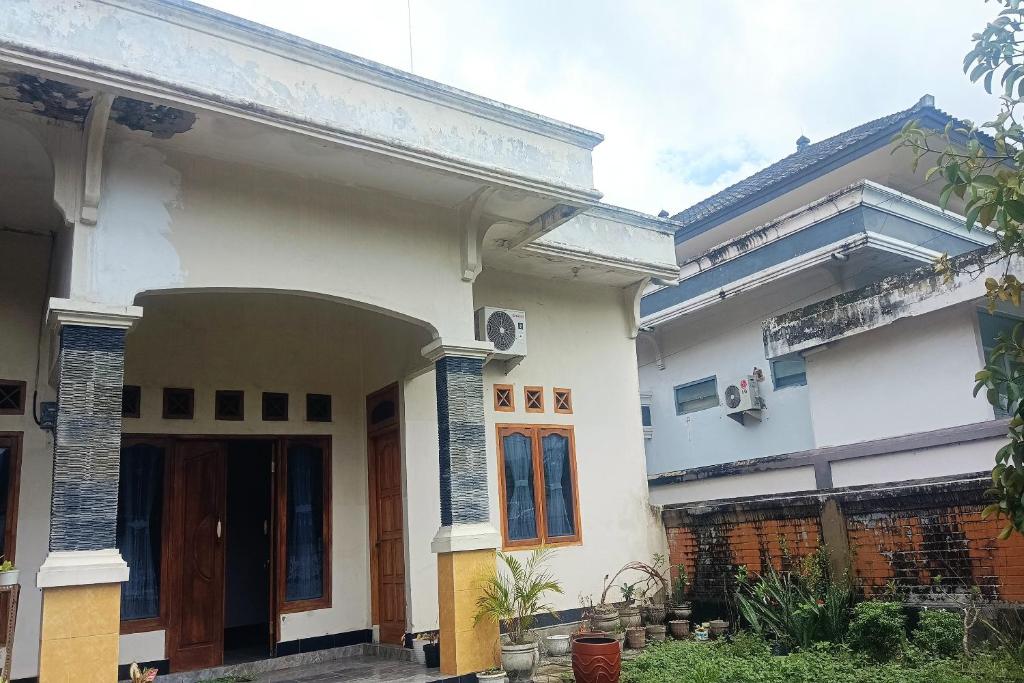 ein weißes Haus mit einer Veranda und einer Tür in der Unterkunft OYO 93425 Homestay Anisa in Kuripan