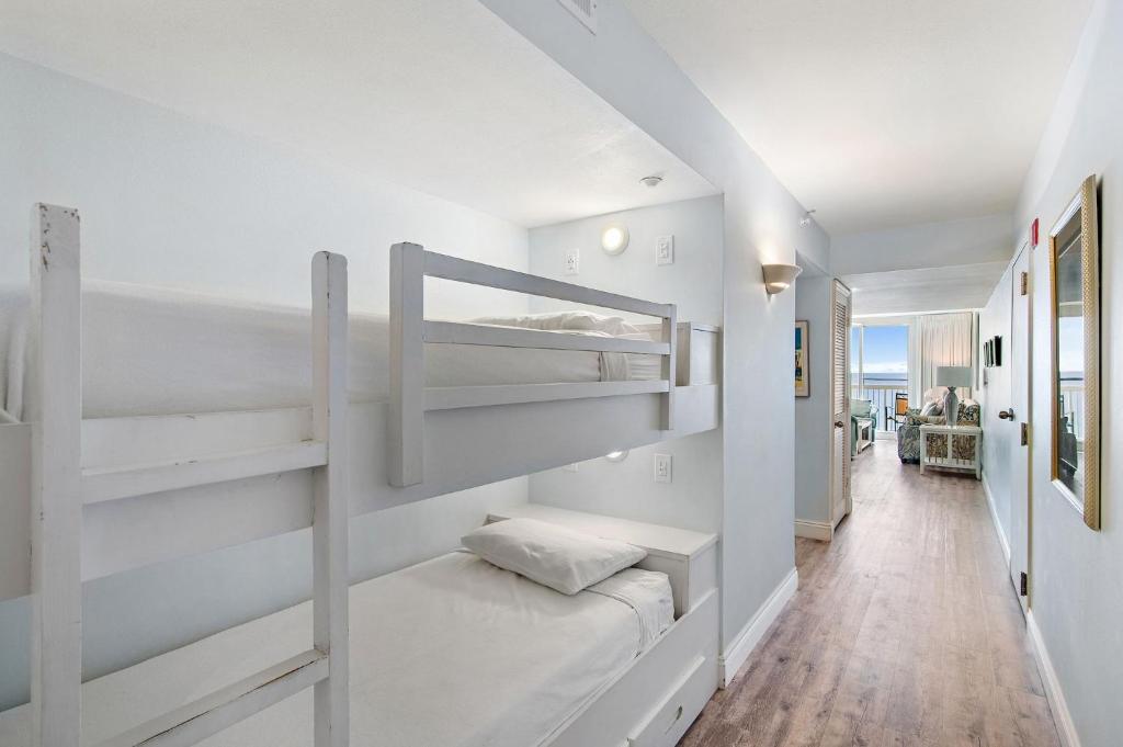 ein Schlafzimmer mit Etagenbetten und einen Flur in der Unterkunft Pelican Beach Resort by Colasan in Destin
