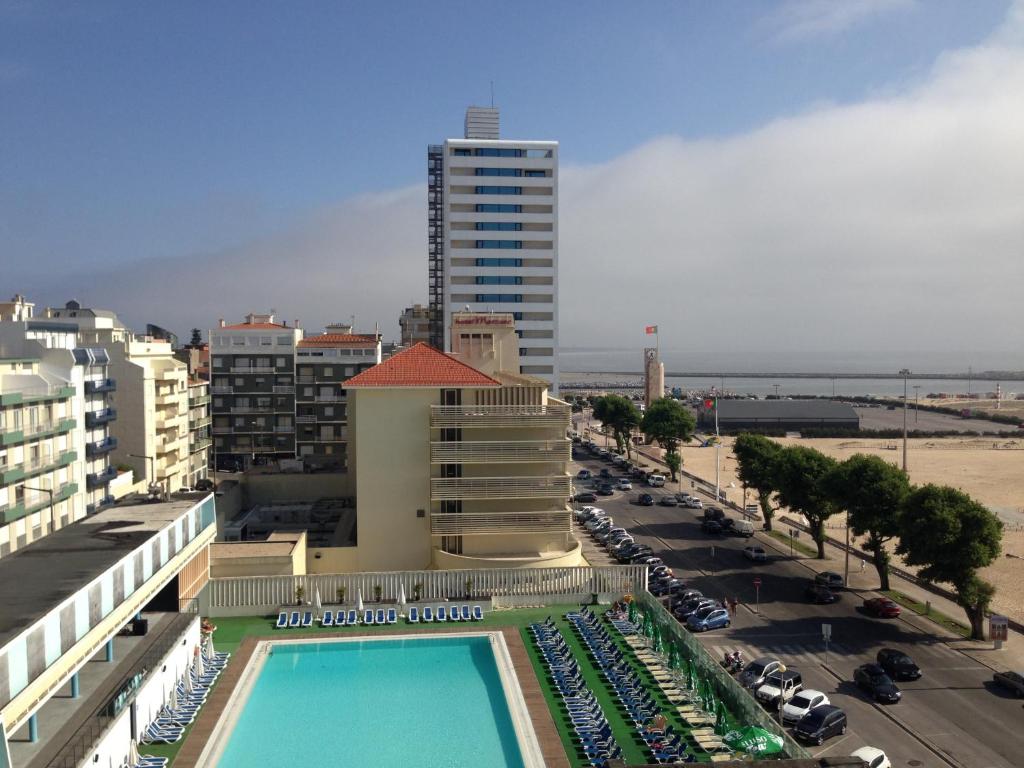 a view of a hotel with a swimming pool and a parking lot at Figueira da Foz Sunset Apartment in Figueira da Foz