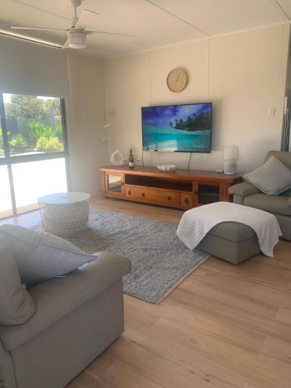 a living room with a couch and a flat screen tv at Investigator Beach Breeze Apartments U1 in Kingscote