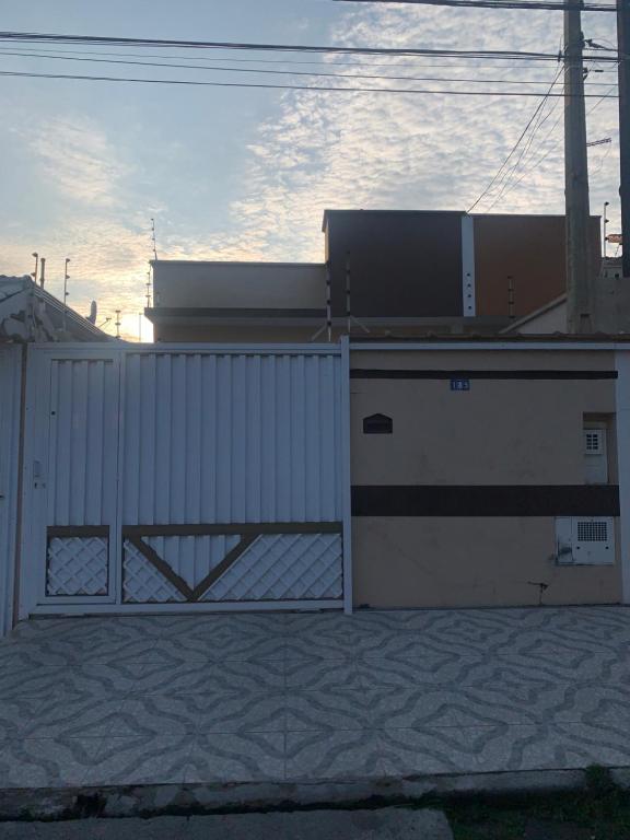 a white fence with a gate in front of a building at Casa em Peruíbe in Peruíbe