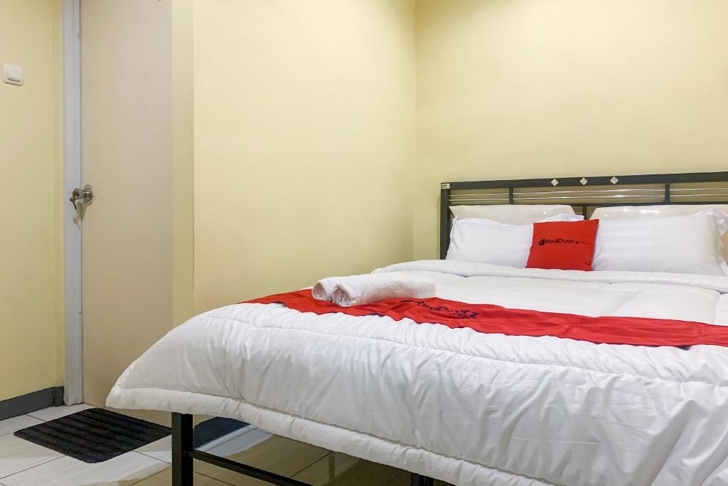 a bedroom with a large bed with red pillows at RedDoorz @ Balaraja Centre Plaza in Tangerang