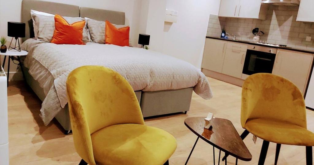 a bedroom with two yellow chairs and a bed at Market Haven Kingsize Studios Town Centre with Netflix, Business & Leisure travellers, multiple units available in Northampton