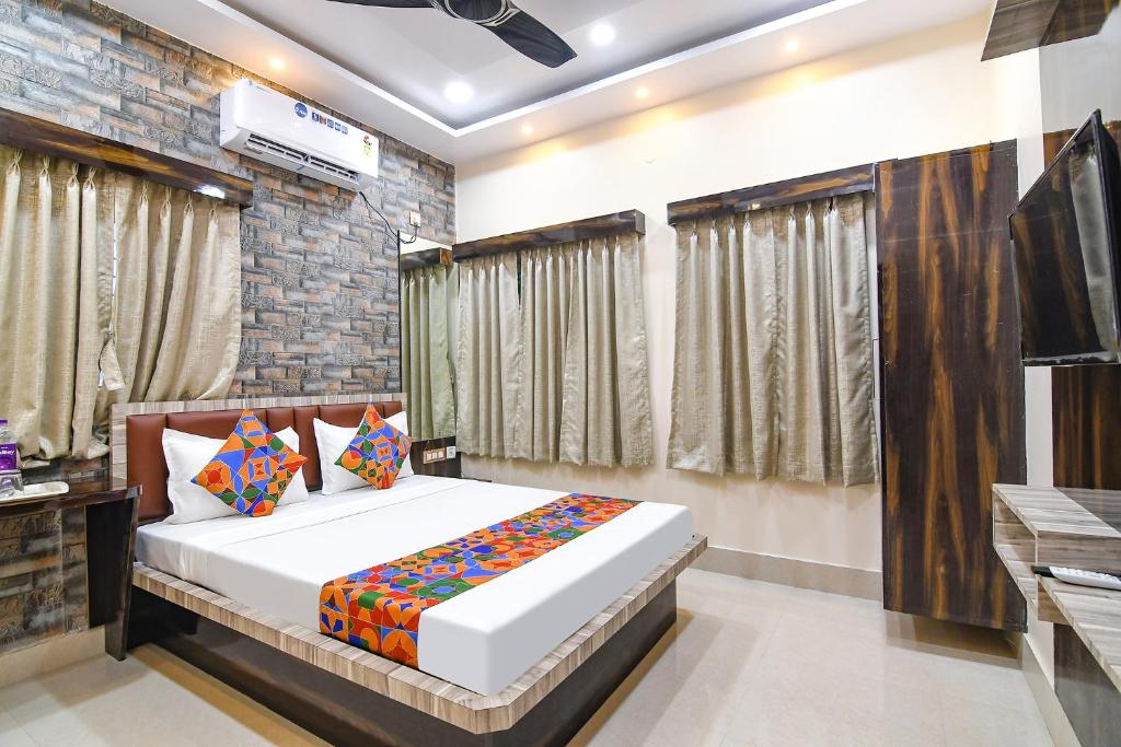 a bedroom with a large bed and a tv at FabHotel Sriya in Durgāpur