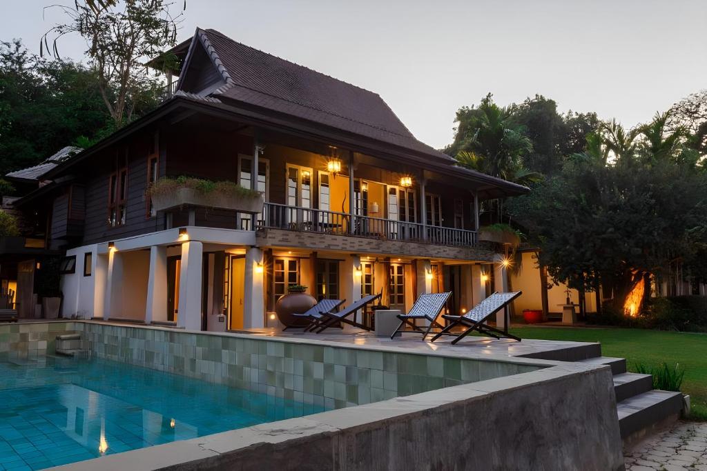 una casa con piscina frente a una casa en Baan Suan Residence เฮือนพักบ้านสวน, en Chiang Mai