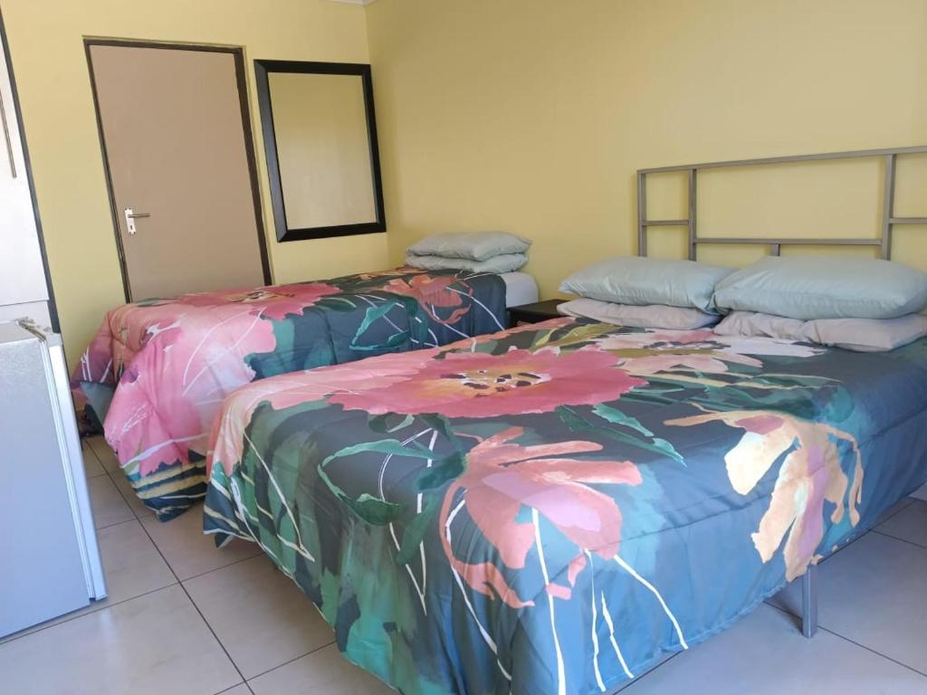 zwei Betten nebeneinander in einem Zimmer in der Unterkunft AGNES GUEST HOUSE in Germiston
