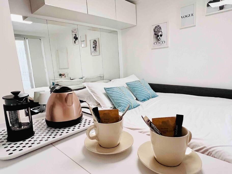 a room with a bed and two cups on a table at Iconic location only 500 meters to The Louvre in Paris