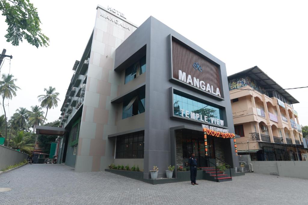 a person standing in front of a building at Hotel Mangala Temple View in Guruvāyūr