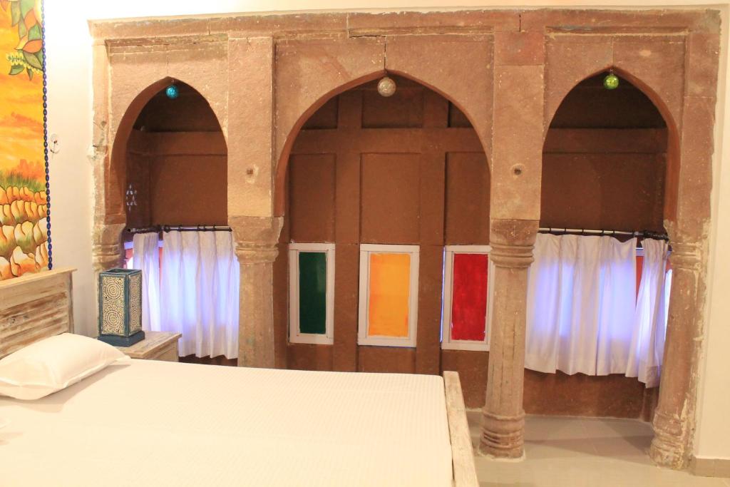 a bedroom with three arched doors with windows at Karma Heritage Guest House in Jodhpur