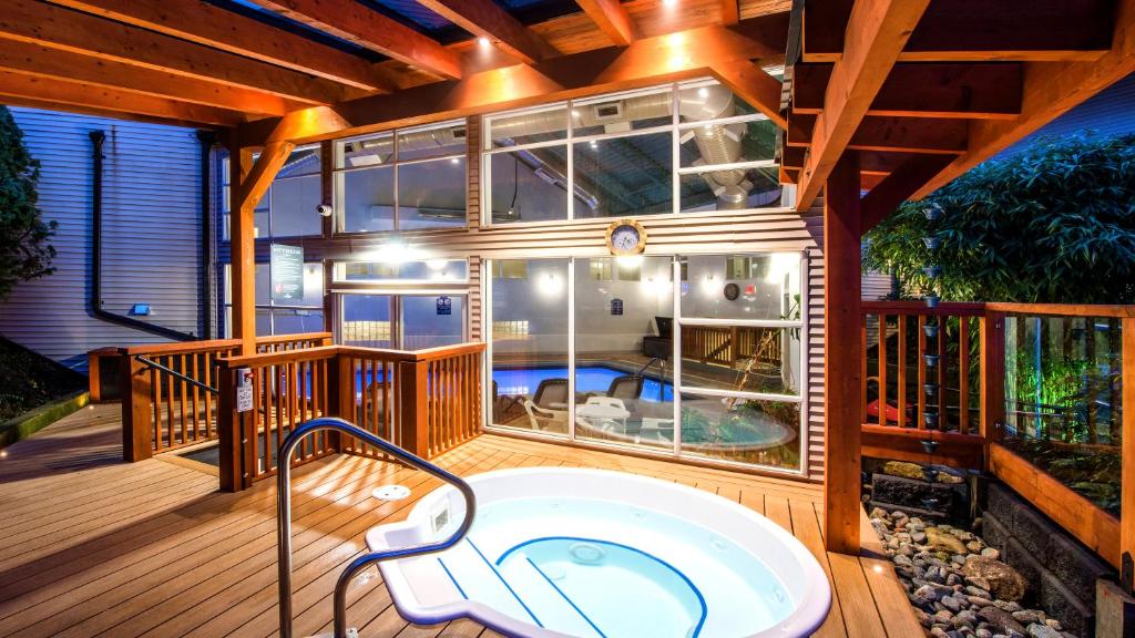 a jacuzzi tub on the deck of a house at Gibsons Garden Hotel in Gibsons