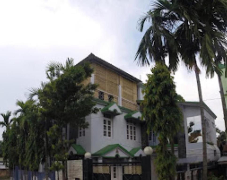 迪馬普爾的住宿－Trinity Villa Dimapur，一座棕榈树大房子前面